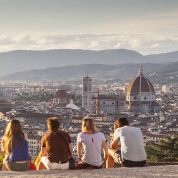 People watch the sunset from the steps of San Miniato al Monte over the city of Florence and the Basilica di Santa Maria del Fiore otherwise known as the Duomo.